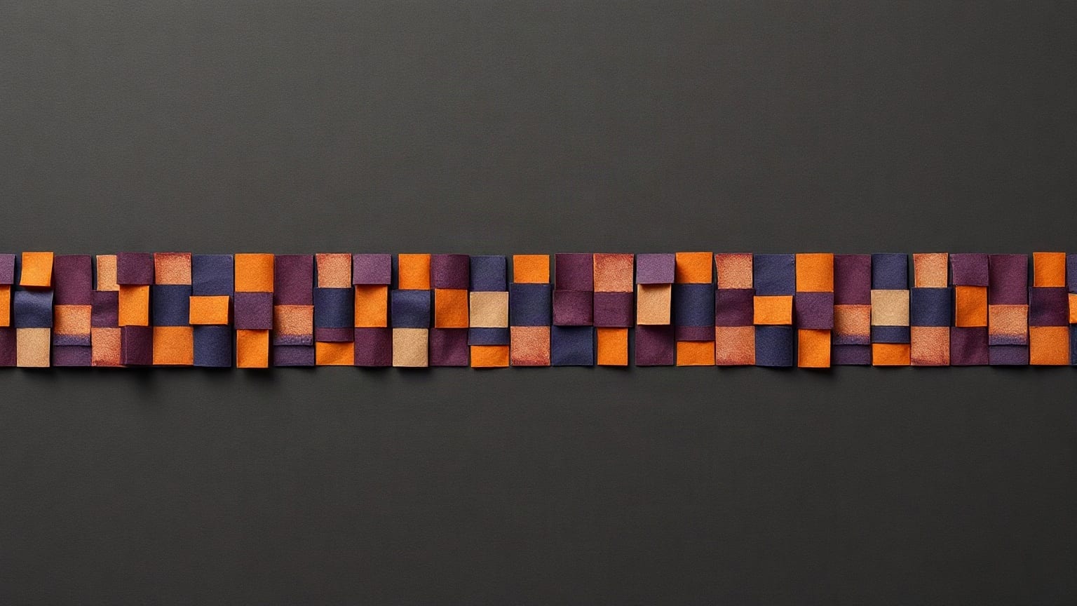 A narrow band of small interlocking paper squares in purple, orange and red across a near-black ground