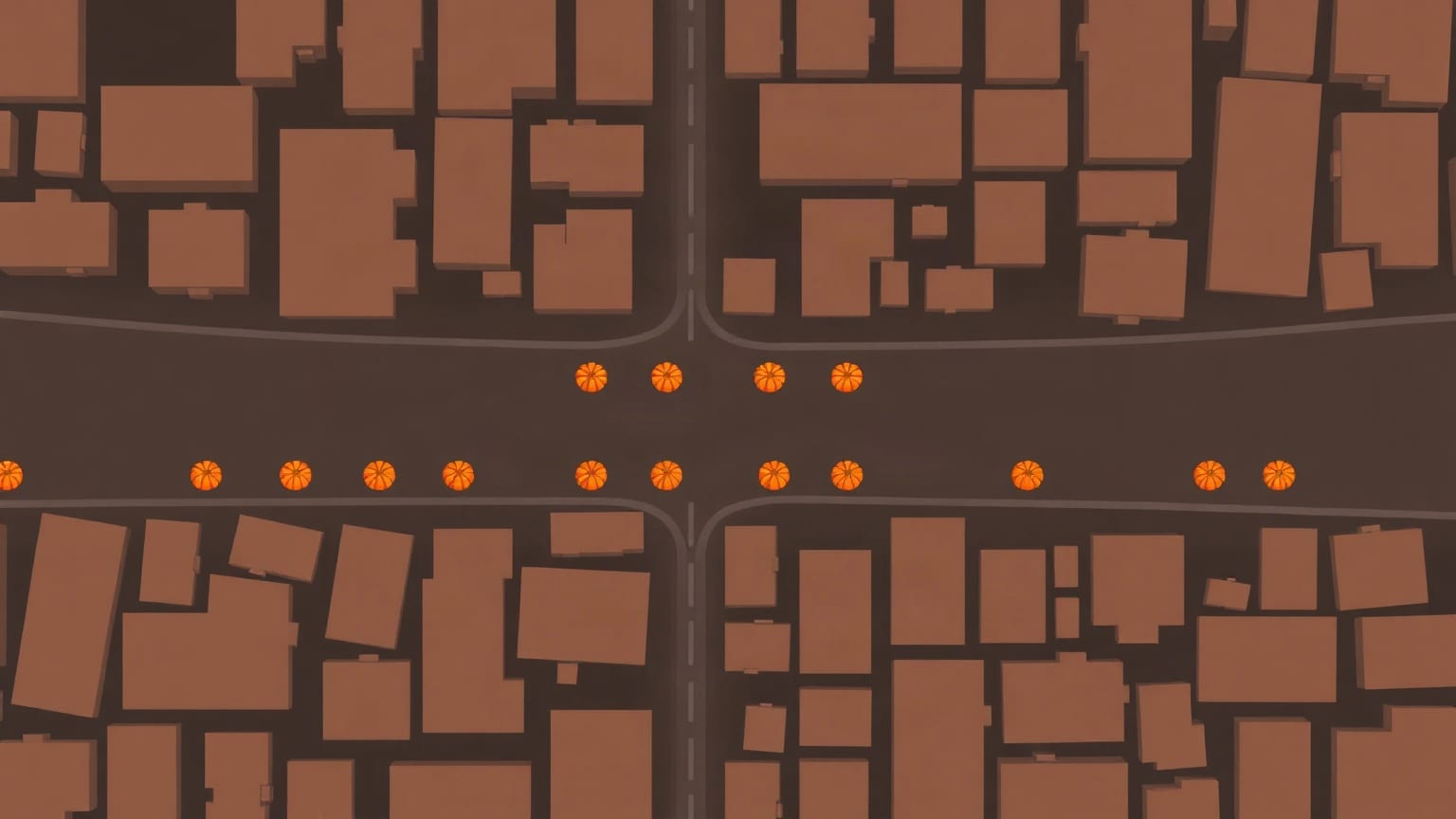 A flat overhead map of city blocks with small orange pumpkins lined along an empty street